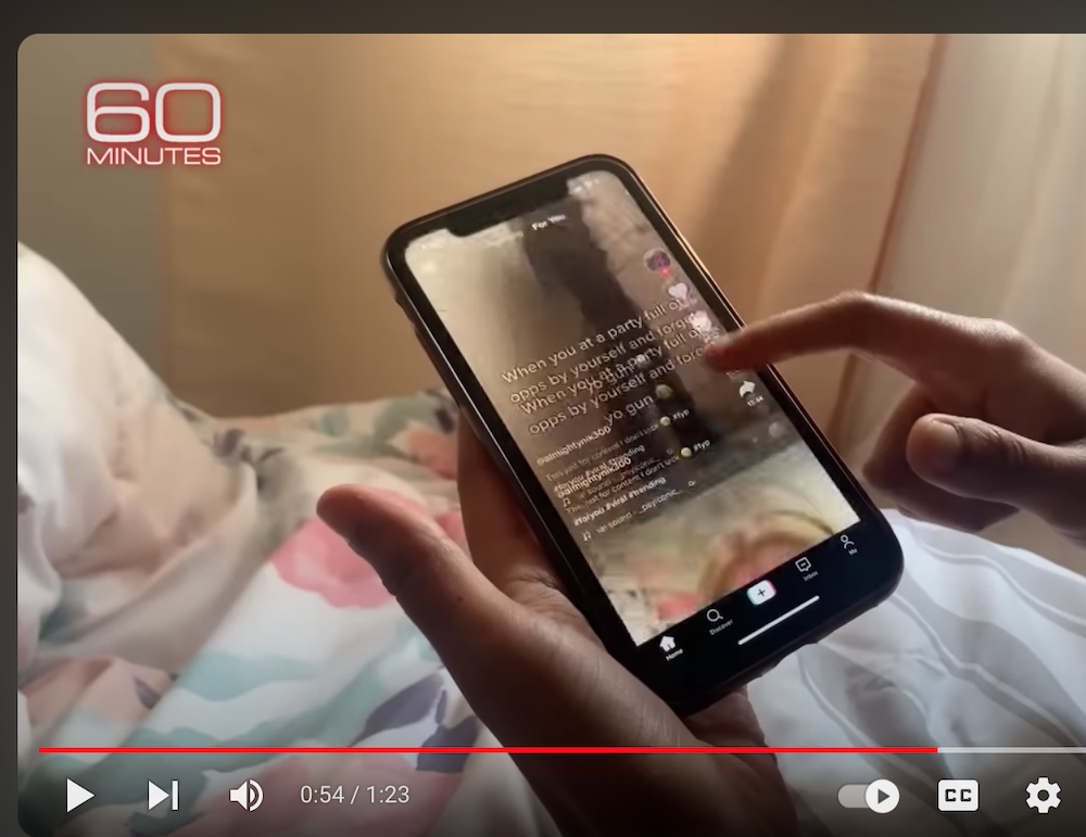 Screenshot from 60 minutes showing a person using TikTok on a mobile phone
